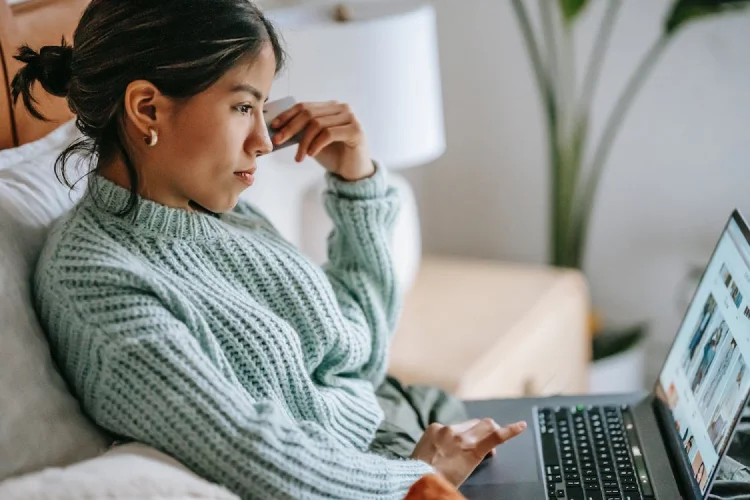 Person shopping for clothing online while sitting on couch