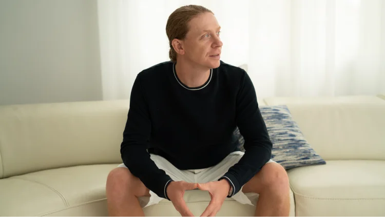 CEO Cobb sits on couch, looking to the right
