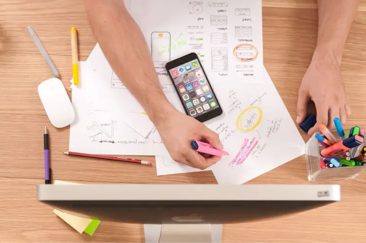A desk with a smart phone and marketing plan