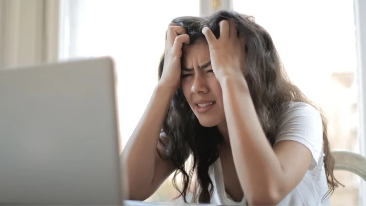 Woman angry at computer ruffles her hair