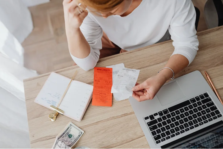 Woman sitting behind the desk and looking at receipts