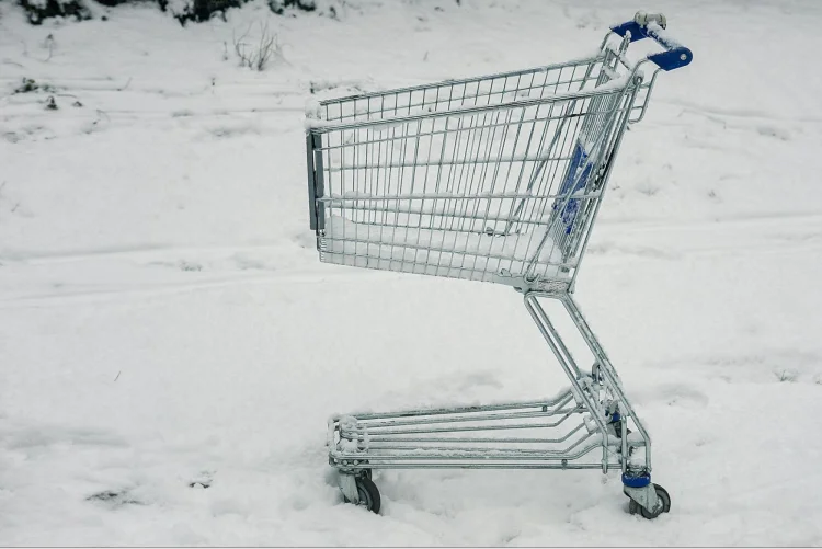 Gray shopping cart on snowy ground