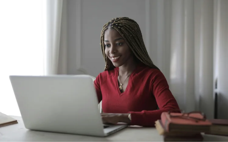 Woman in red long sleeve shirt using macbook