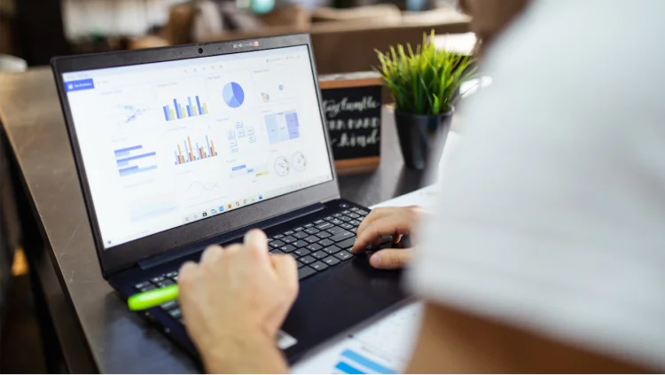 Business person looks at a report on a laptop