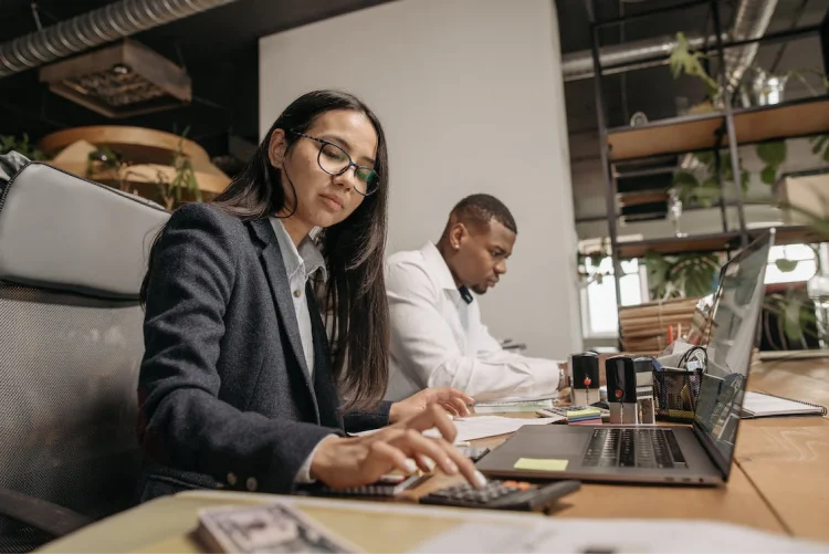 Two people calculating revenue vs. profit